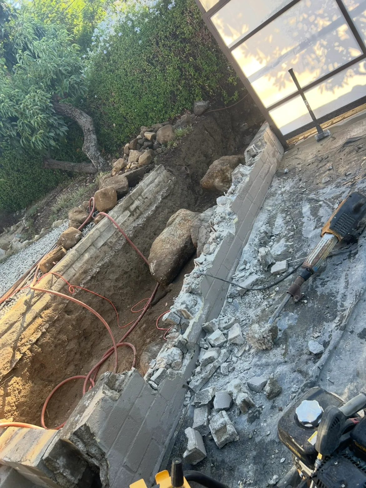 Demolition and excavation along the wall line before the new block wall